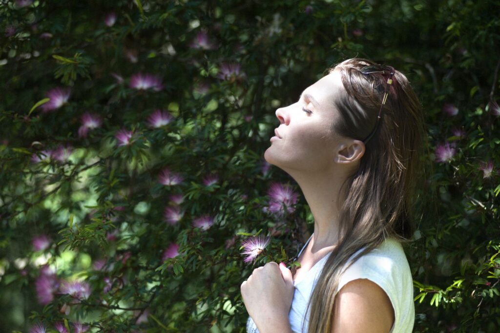 Femme apaisée, les yeux fermés au soleil, retrouvant le calme