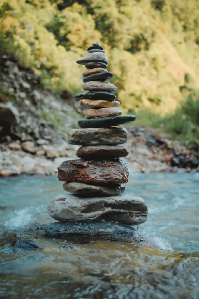Pierres en équilibre au bord d'une rivière, symbolisant l'harmonie et la connexion